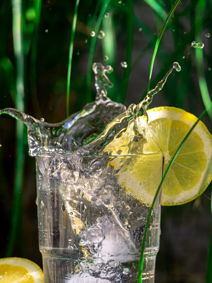 Dramatic capture of a lemon water splash in a glass, highlighting freshness and summer vibes.